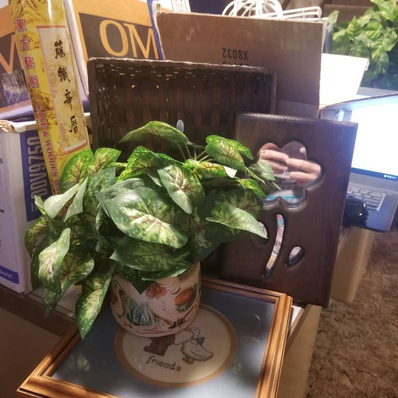 lot 12184 image: Small planter with faux plants, wall decor of cross stitch, butterfly and flower mirror, duck lotion holder.